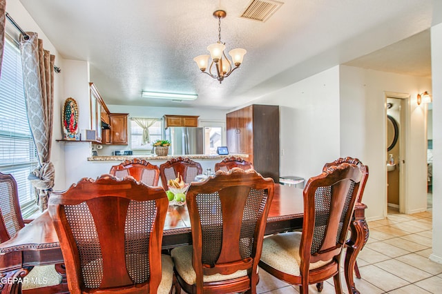 14253 Hacienda Rock Dr, El Paso, TX 79938 - dining space featuring a chandelier, light tile patterned floors, a textured ceiling, and baseboards