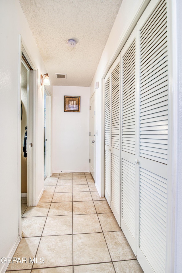 14253 Hacienda Rock Dr, El Paso, TX 79938 - corridor featuring a textured ceiling and light tile patterned floors