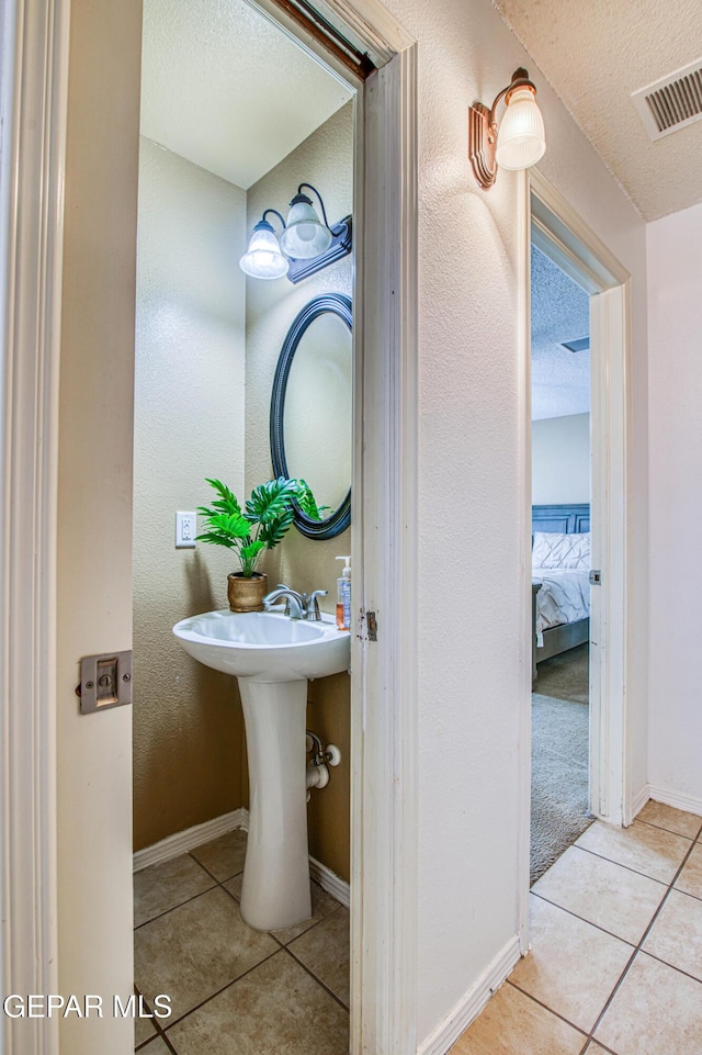 14253 Hacienda Rock Dr, El Paso, TX 79938 - bathroom with tile patterned flooring, a textured ceiling, baseboards, and connected bathroom