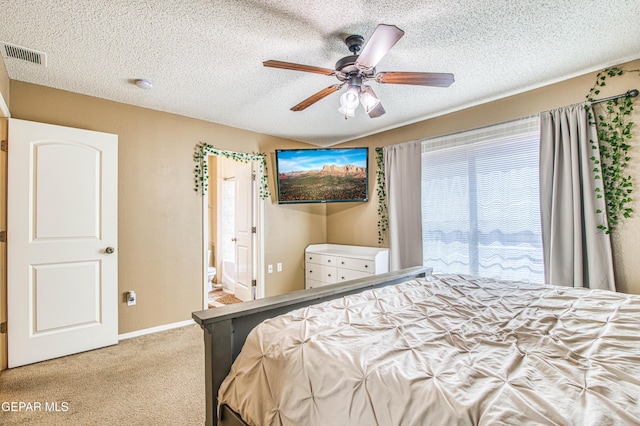 14253 Hacienda Rock Dr, El Paso, TX 79938 - carpeted bedroom featuring a textured ceiling, ensuite bathroom, baseboards, and a ceiling fan