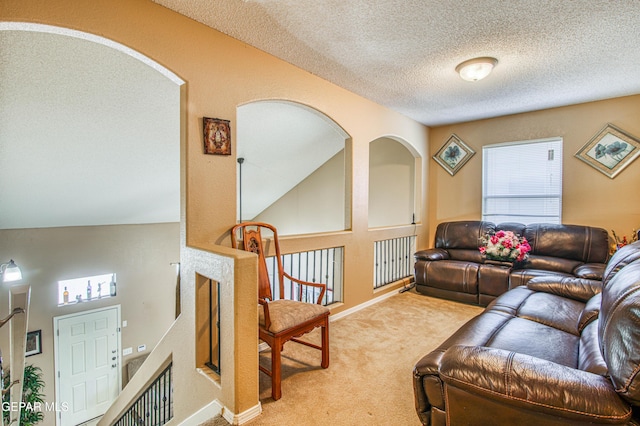 14253 Hacienda Rock Dr, El Paso, TX 79938 - living room with carpet, baseboards, a textured ceiling, and arched walkways