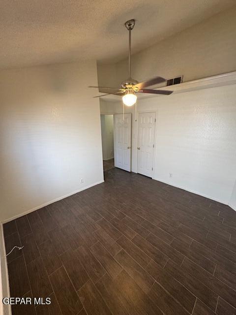 spare room with visible vents, dark wood finished floors, ceiling fan, and baseboards