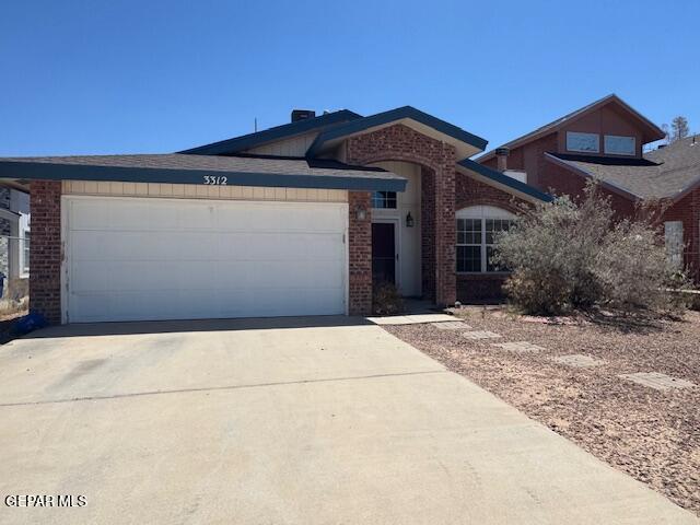 view of front facade featuring brick siding, an attached garage, and concrete driveway