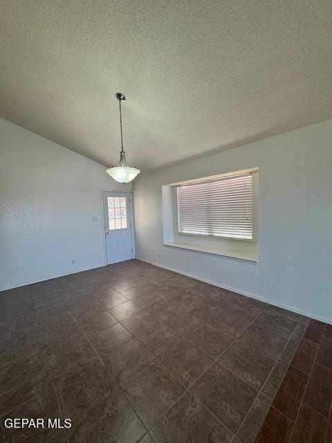 unfurnished dining area with a textured ceiling