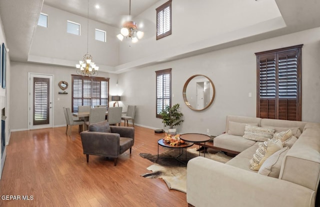 12164 Sitting Bull Dr, El Paso, TX 79936 - living area with a chandelier, wood finished floors, a towering ceiling, baseboards, and a ceiling fan