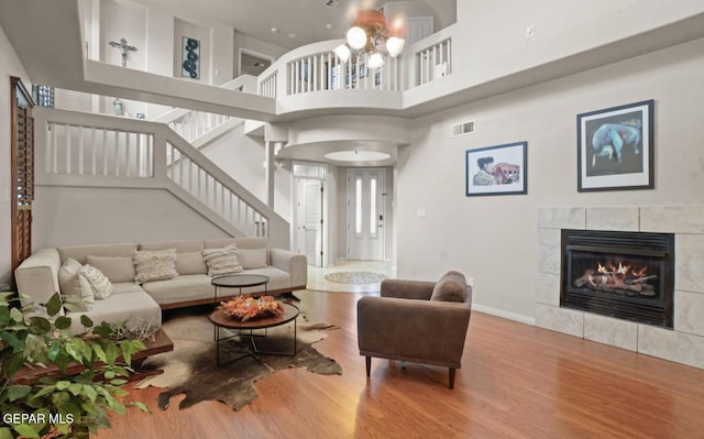 12164 Sitting Bull Dr, El Paso, TX 79936 - living area with wood finished floors, a fireplace, stairs, a towering ceiling, and a chandelier
