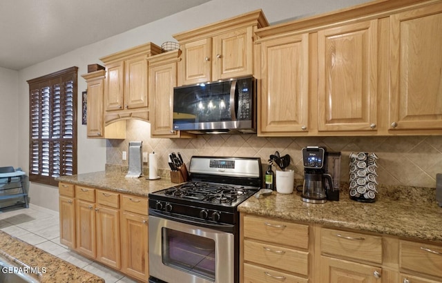 12164 Sitting Bull Dr, El Paso, TX 79936 - kitchen with stainless steel appliances, backsplash, light tile patterned flooring, and light brown cabinetry