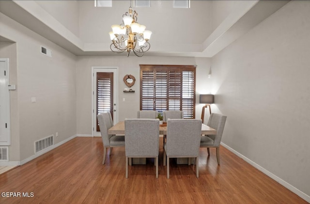 12164 Sitting Bull Dr, El Paso, TX 79936 - dining space featuring a chandelier, wood finished floors, baseboards, and a tray ceiling
