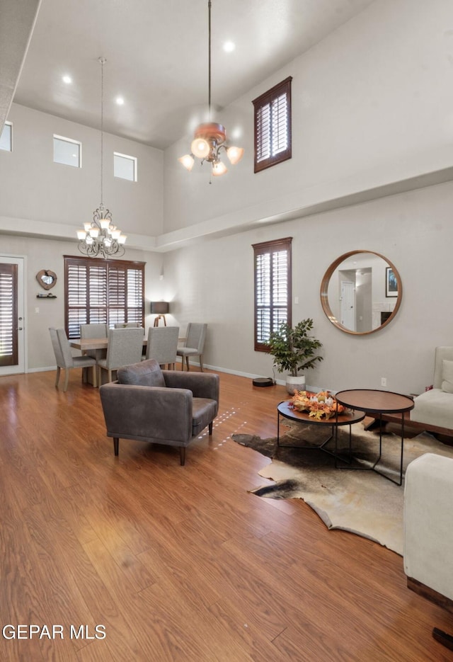 12164 Sitting Bull Dr, El Paso, TX 79936 - living area with a high ceiling, a chandelier, wood finished floors, recessed lighting, and baseboards