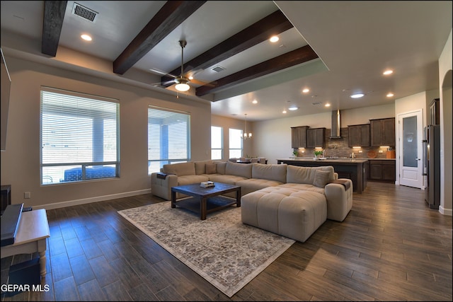 living area featuring ceiling fan, visible vents, baseboards, beamed ceiling, and dark wood-type flooring