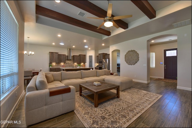 living area with visible vents, arched walkways, ceiling fan with notable chandelier, and beamed ceiling