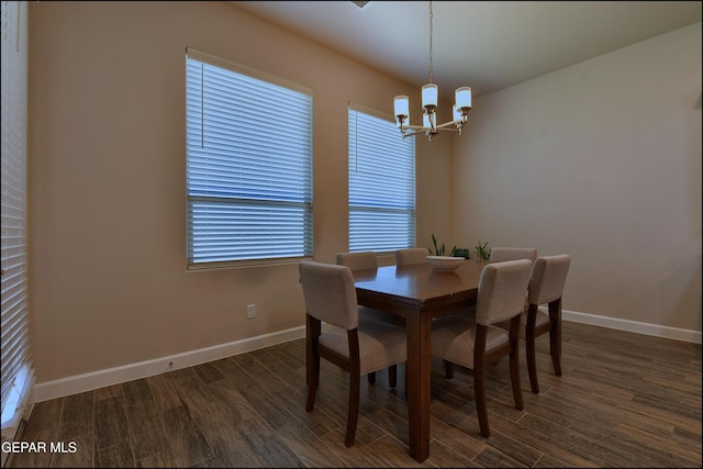 dining space with baseboards, a notable chandelier, and dark wood-style floors