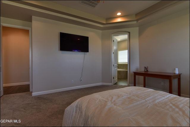 carpeted bedroom featuring ensuite bath, arched walkways, recessed lighting, baseboards, and visible vents