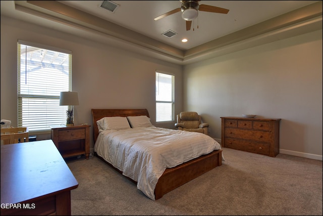 carpeted bedroom featuring recessed lighting, baseboards, visible vents, and a raised ceiling