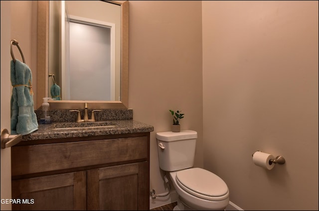 bathroom featuring vanity, baseboards, and toilet