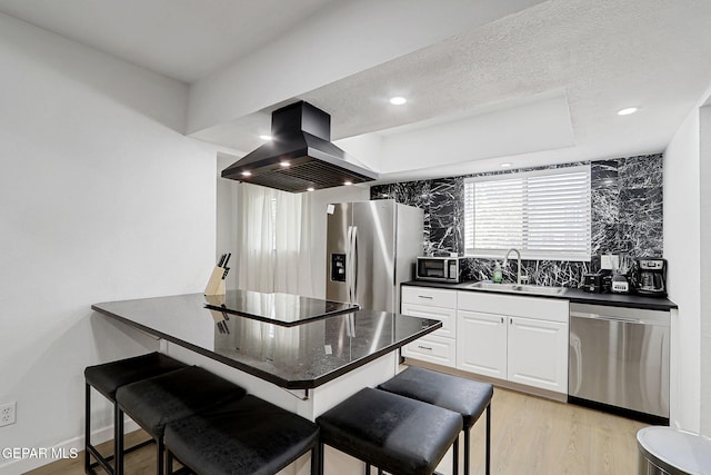 kitchen featuring decorative backsplash, a breakfast bar area, island exhaust hood, a sink, and stainless steel appliances