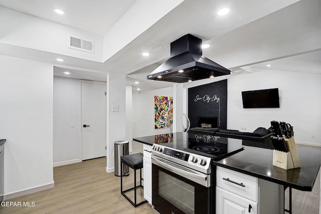 kitchen with stainless steel range with electric cooktop, a fireplace, open floor plan, island range hood, and visible vents