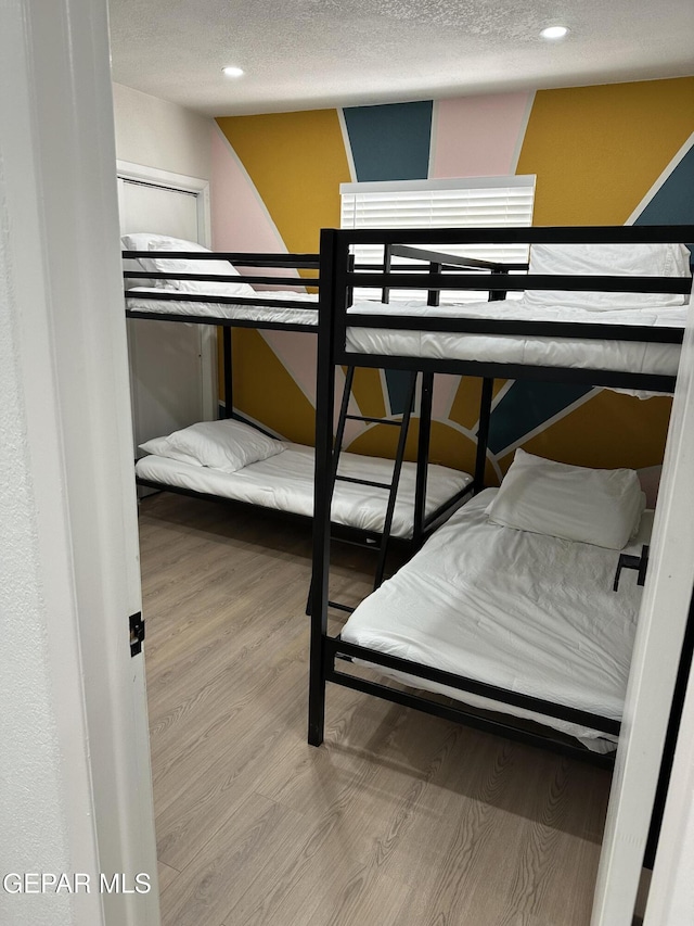 bedroom with recessed lighting and wood finished floors