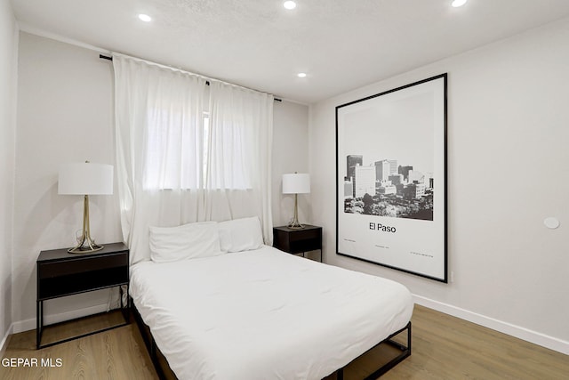 bedroom with baseboards, recessed lighting, and wood finished floors