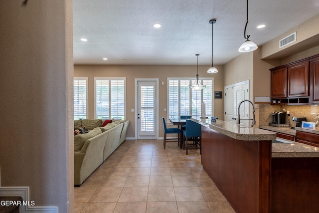 kitchen featuring recessed lighting, light tile patterned floors, tasteful backsplash, visible vents, and pendant lighting