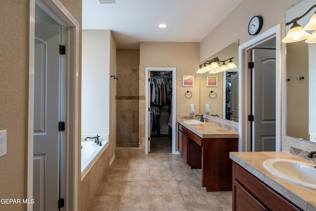 full bath featuring a sink, a walk in closet, a bath, and a shower stall