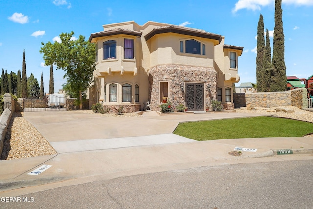1859 Luis Gomez Place, El Paso, TX 79936 - mediterranean / spanish-style house with stone siding, fence, stucco siding, concrete driveway, and a tiled roof
