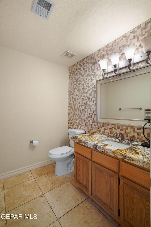 1859 Luis Gomez Place, El Paso, TX 79936 - bathroom featuring toilet, vanity, tile patterned flooring, baseboards, and a textured ceiling