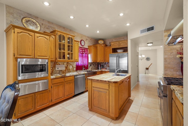 1859 Luis Gomez Place, El Paso, TX 79936 - kitchen with premium appliances, a warming drawer, a center island with sink, a sink, and butcher block countertops