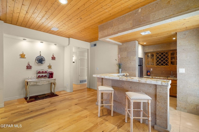 1859 Luis Gomez Place, El Paso, TX 79936 - kitchen featuring a kitchen bar, wooden ceiling, refrigerator, a sink, and light wood-type flooring