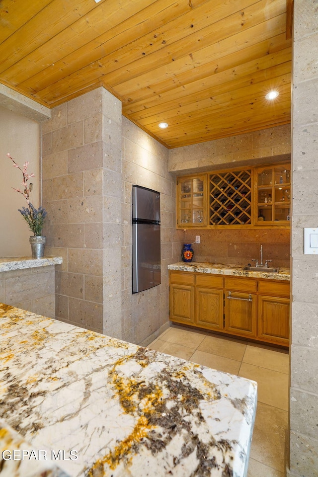 1859 Luis Gomez Place, El Paso, TX 79936 - kitchen with wood ceiling, a sink, brown cabinets, light tile patterned floors, and glass insert cabinets