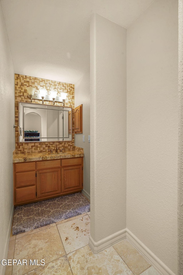 1859 Luis Gomez Place, El Paso, TX 79936 - bathroom featuring vanity, baseboards, and tasteful backsplash