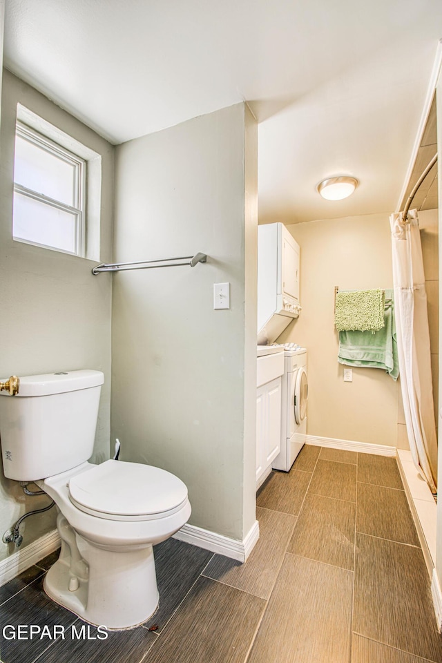 full bath with stacked washer and clothes dryer, toilet, curtained shower, and baseboards