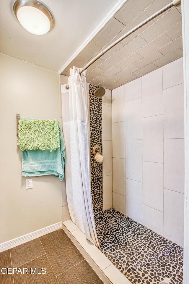 full bath with baseboards and a shower stall