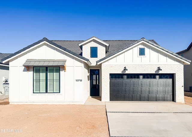 modern inspired farmhouse featuring a garage, board and batten siding, concrete driveway, and brick siding