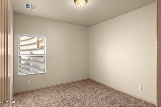 carpeted empty room featuring baseboards and visible vents