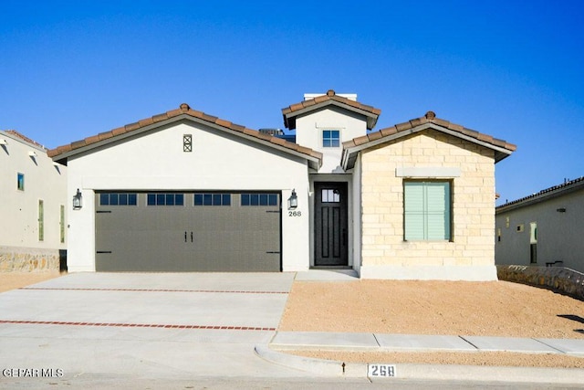 view of front of property with a garage, stucco siding, a tiled roof, and concrete driveway
