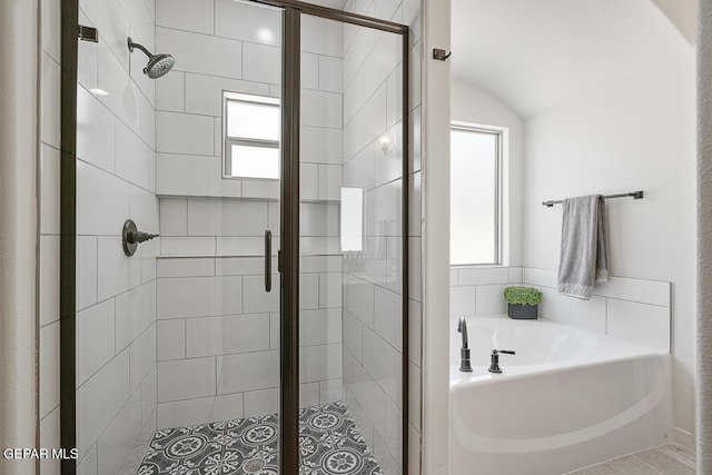 bathroom with a healthy amount of sunlight, a garden tub, and a stall shower