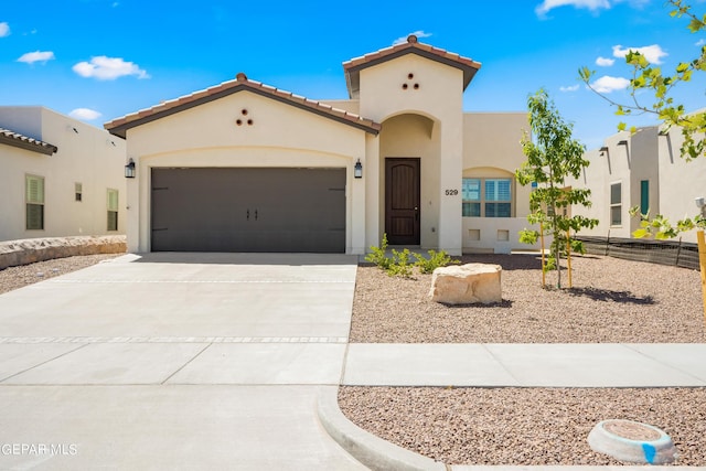 921 Raegil St, El Paso, TX 79928 - mediterranean / spanish home featuring stucco siding, concrete driveway, a garage, and a tiled roof