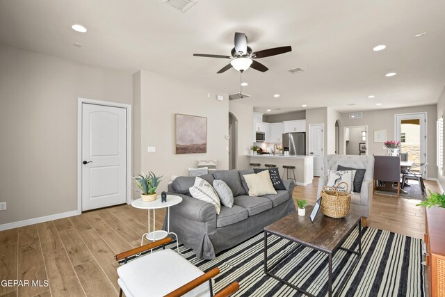 921 Raegil St, El Paso, TX 79928 - living area featuring arched walkways, light wood-style floors, ceiling fan, baseboards, and recessed lighting