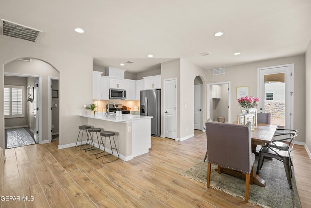 921 Raegil St, El Paso, TX 79928 - dining space featuring arched walkways, baseboards, recessed lighting, and light wood finished floors