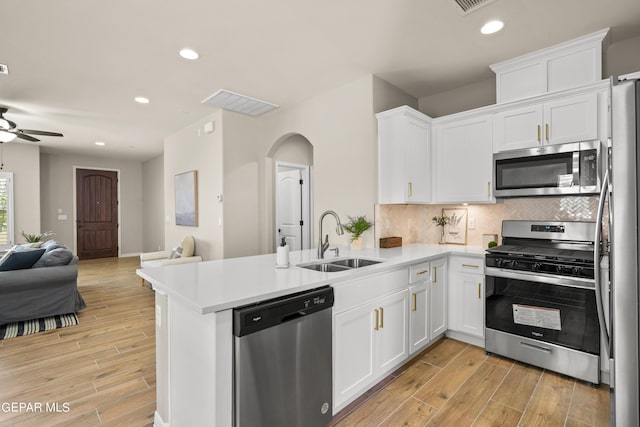 921 Raegil St, El Paso, TX 79928 - kitchen featuring appliances with stainless steel finishes, a sink, open floor plan, white cabinets, and a peninsula
