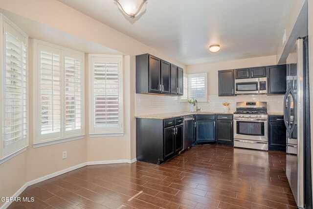 527 Longleaf Pl, El Paso, TX 79928 - kitchen featuring a sink, decorative backsplash, stainless steel appliances, and dark wood-style flooring