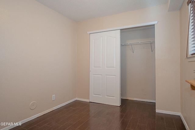 527 Longleaf Pl, El Paso, TX 79928 - unfurnished bedroom with baseboards, a closet, and dark wood-style floors