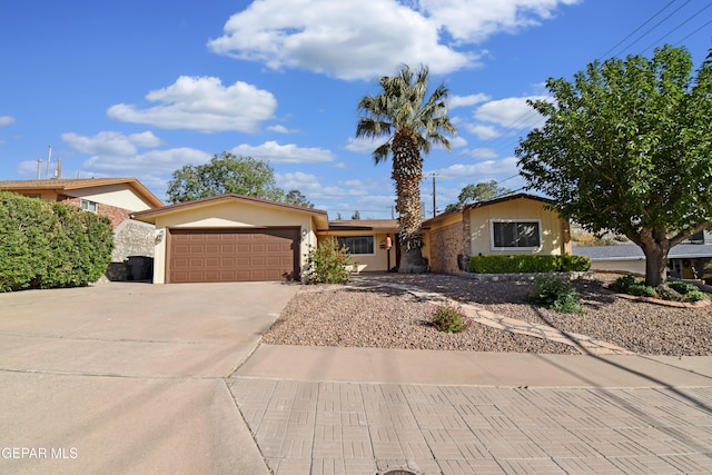 single story home featuring concrete driveway, an attached garage, and stucco siding