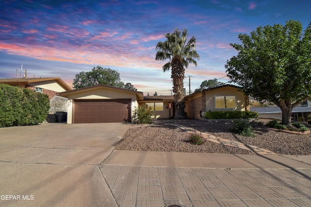 single story home with concrete driveway, a garage, and stucco siding