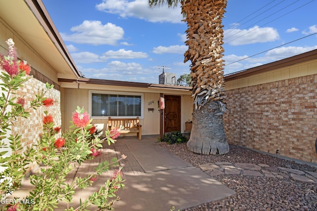 doorway to property with brick siding