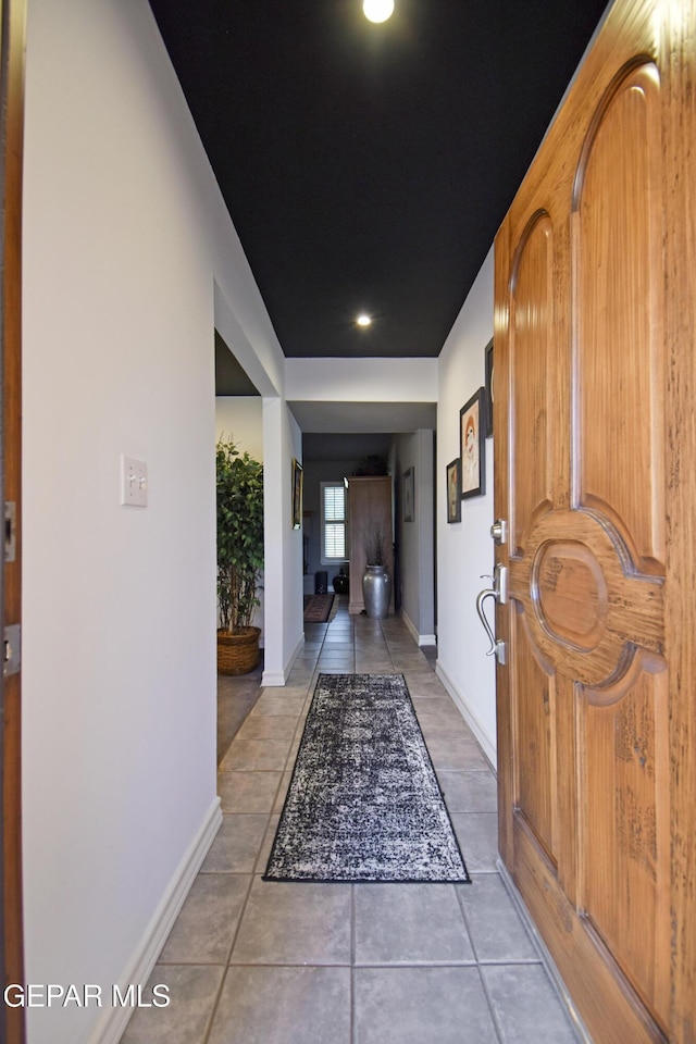 hall with baseboards, light tile patterned flooring, and recessed lighting