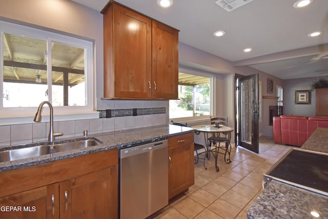 kitchen featuring light tile patterned floors, visible vents, a sink, brown cabinets, and stainless steel appliances