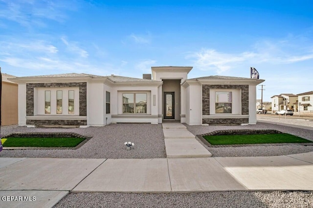 prairie-style home featuring stone siding and stucco siding