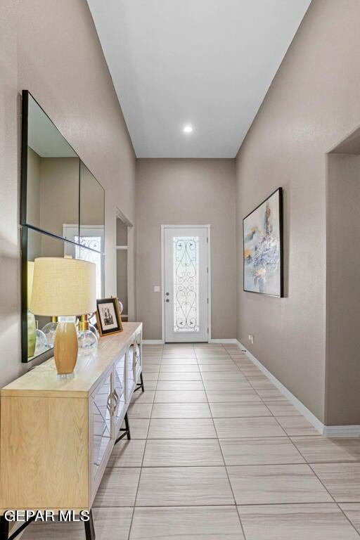 foyer entrance featuring baseboards and light tile patterned floors